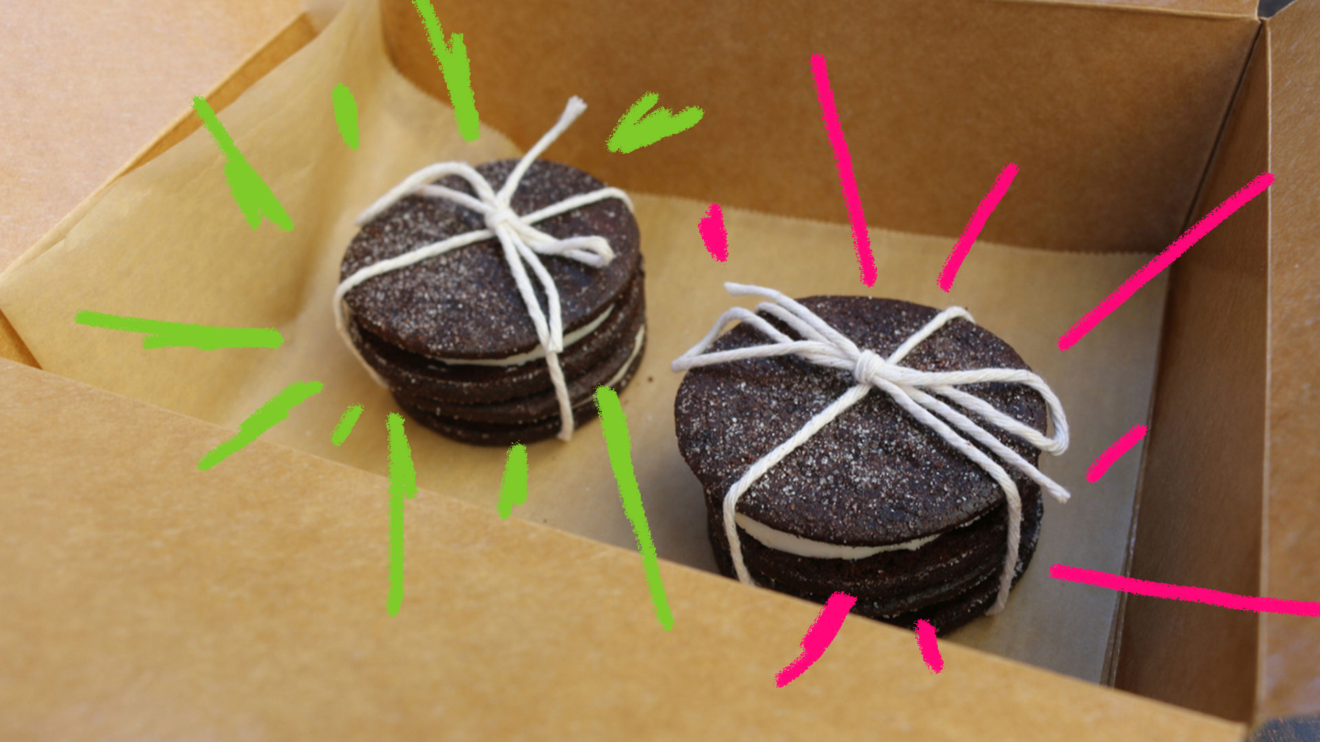 Biscoito recheado caseiro: foto de dois biscoitos recheados embrulhados com barbante dentro de uma caixa da papelão de presente.