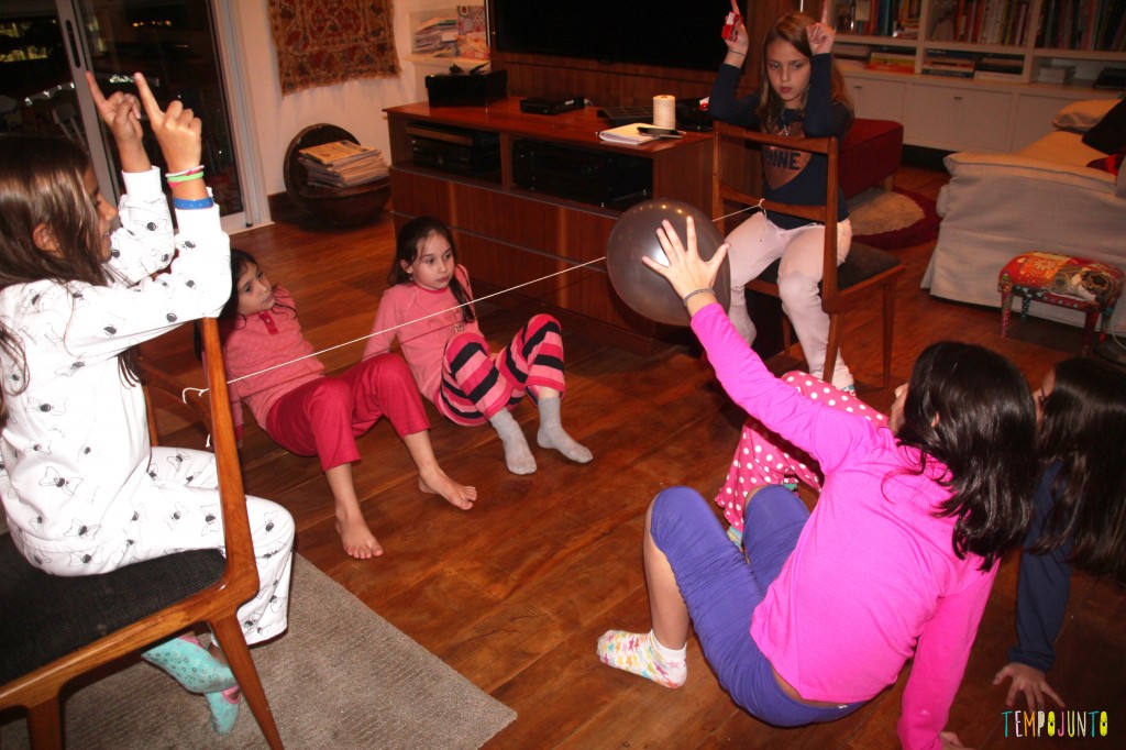 Brincadeiras para fazer em grupo: foto de crianças agachadas que brincam em uma sala de estar.