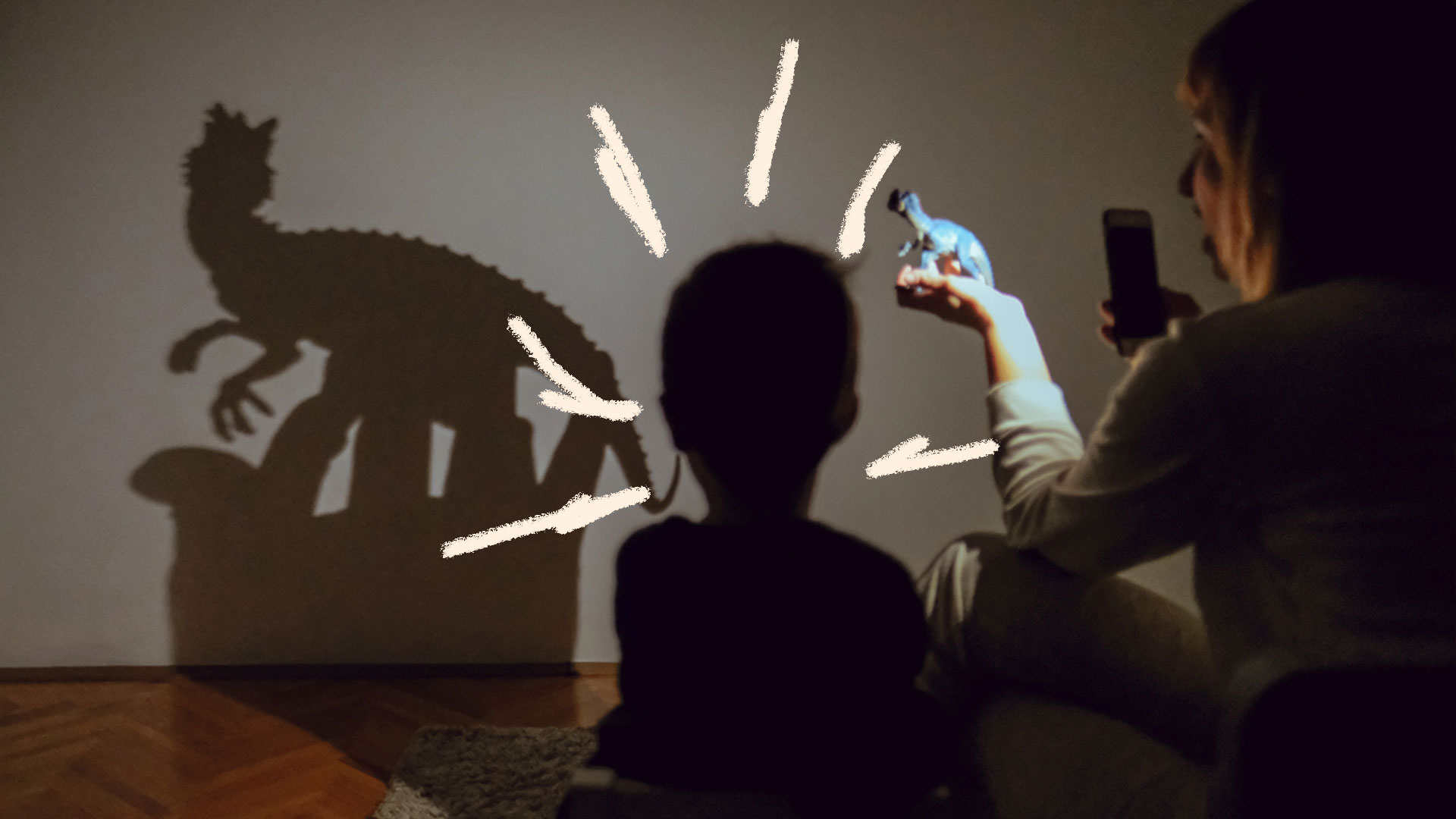 Brincadeiras com lanterna: foto de um criança que brinca com sua sombra, no escuro.