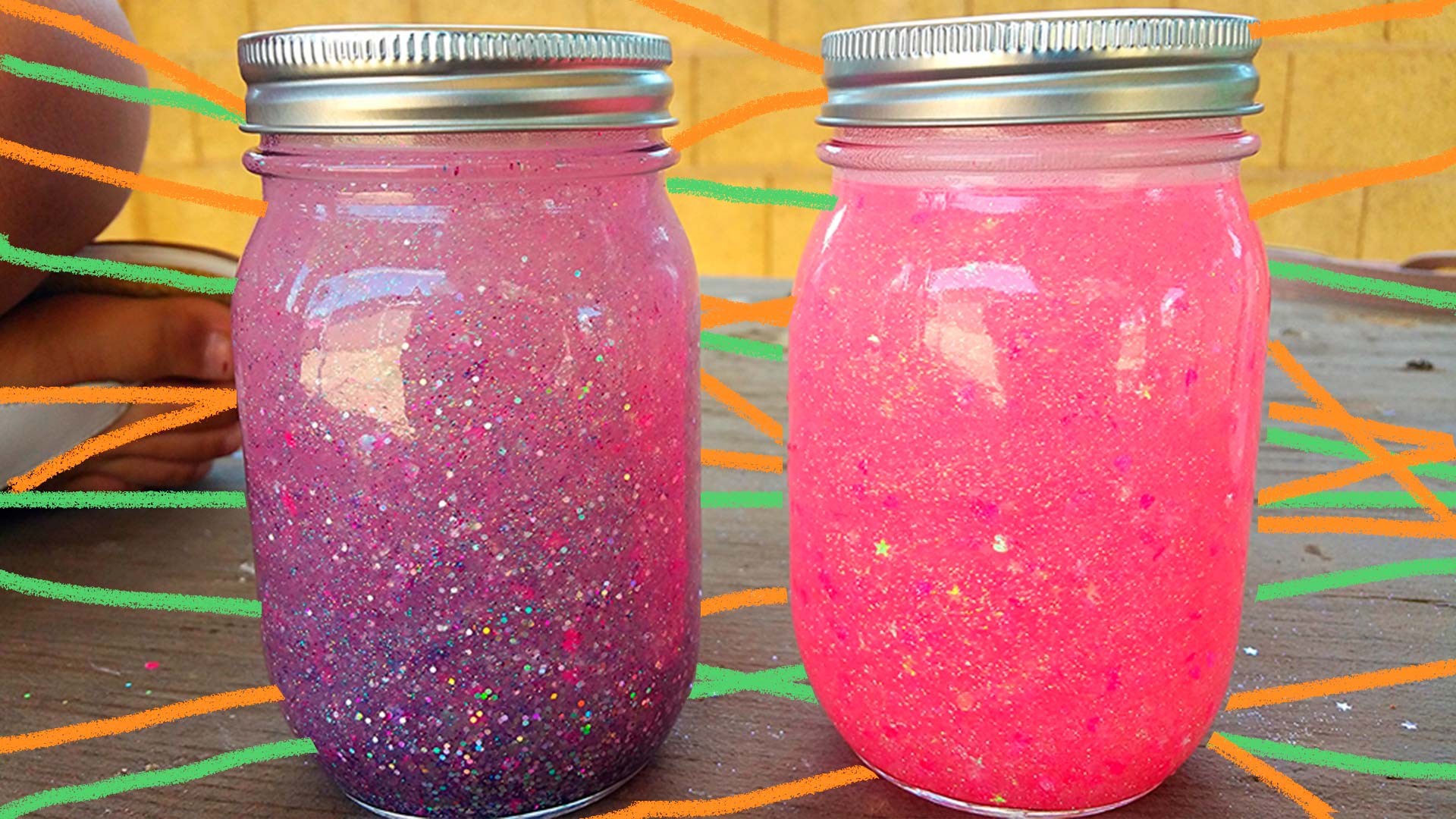 Dois potes de vidro com água, glitter e brocal cor-de-rosa e roxo.