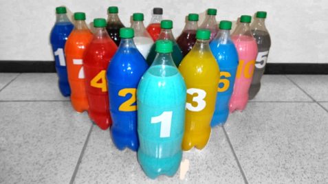 15 garrafas PET cheias de líquido colorido, numeradas em ordem decrescente em um arranjo triangular.