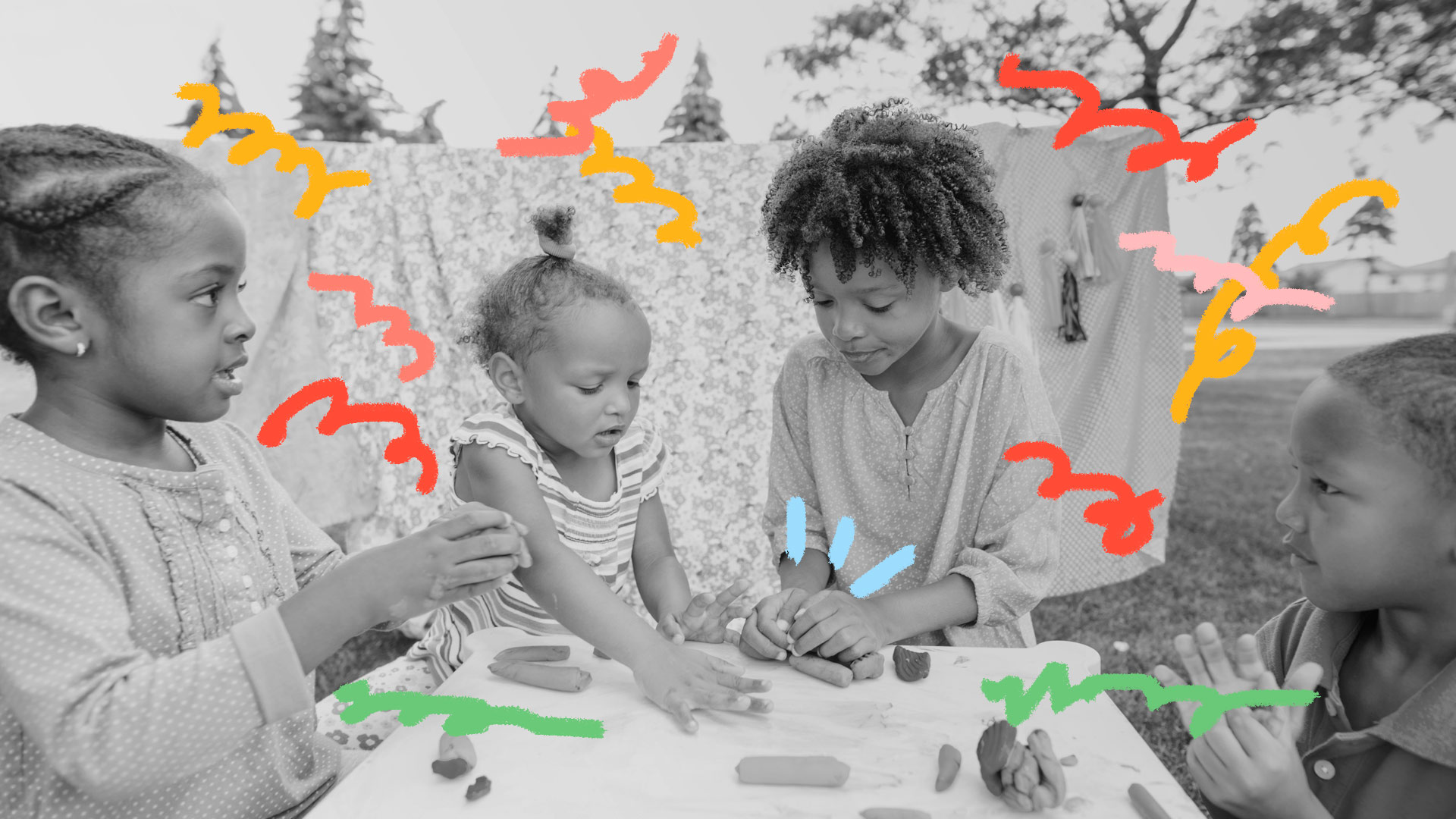 Brincadeiras sensoriais acima dos 2 anos: foto preto e branca de duas meninas, que brincam com massinha em uma mesa.