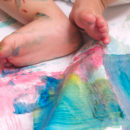 Pés de bebês em uma superfície com tinta colorida