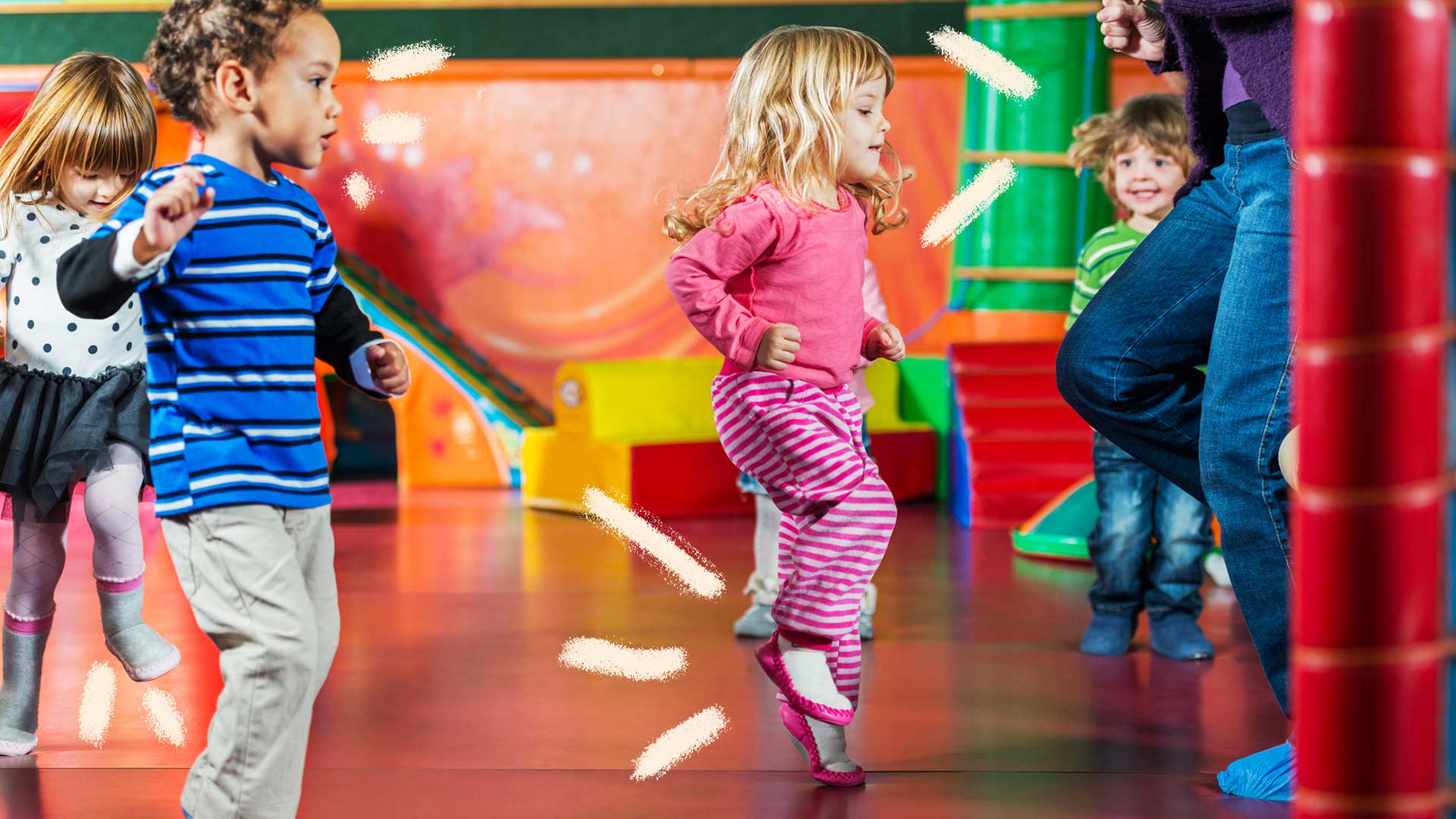 No centro da foto, uma menina dança enquanto outras crianças observam