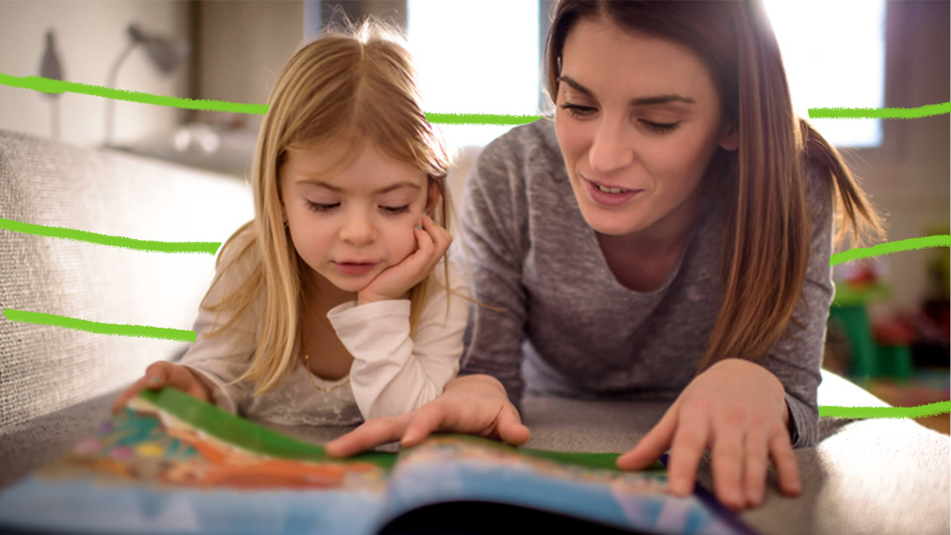 Mulher e menina de cotovelos apoiados lendo livro