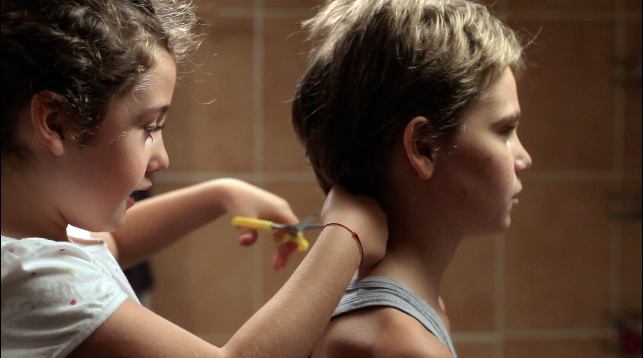 Imagem do filme Tomboy mostra duas crianças cortando o cabelo uma da outra