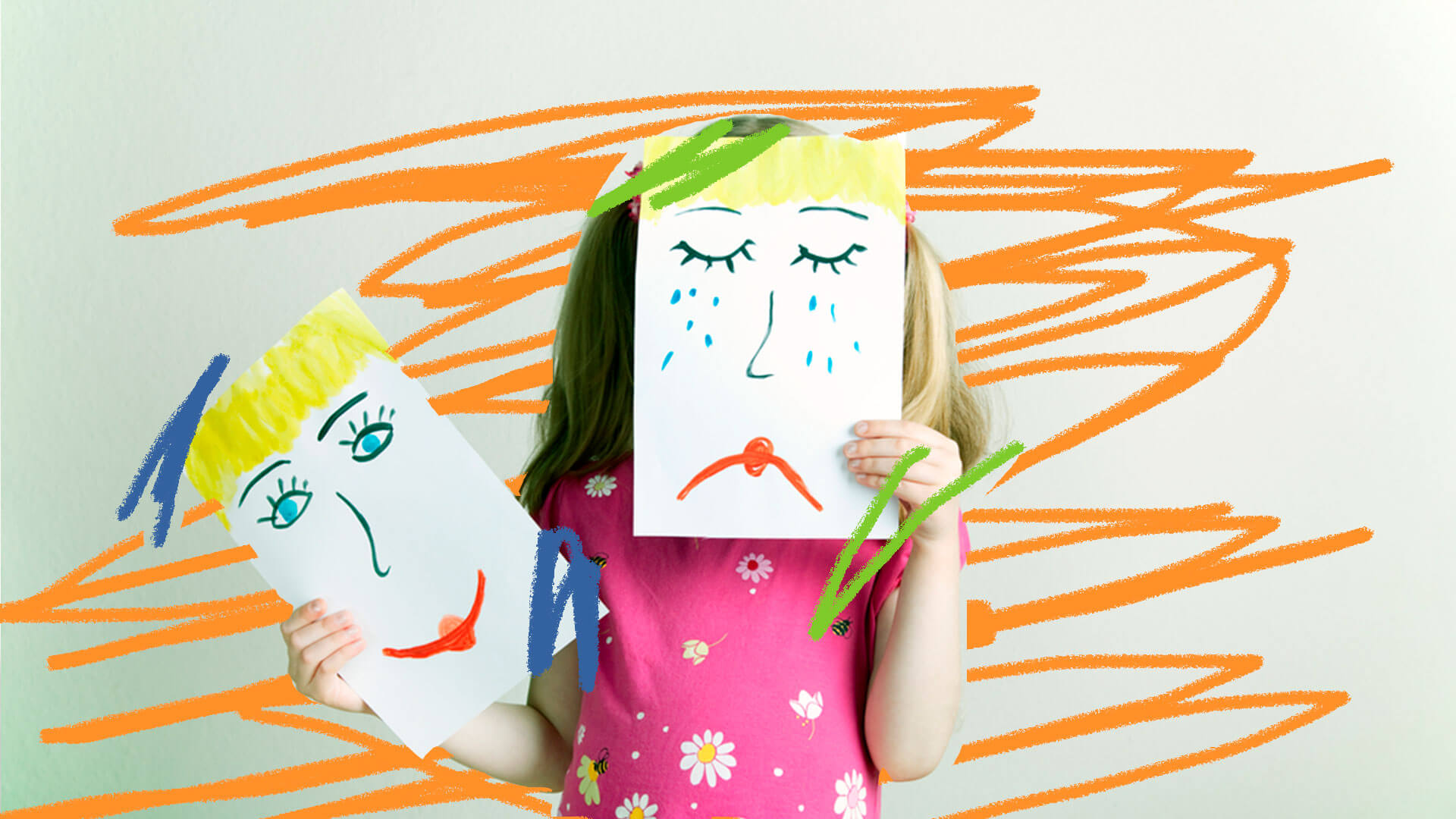 Uma garotinha está segurando duas folhas de sulfite. Uma delas cobre o seu rosto e tem uma feição triste desenhada. A outra, ao lado, tem uma feição alegre.