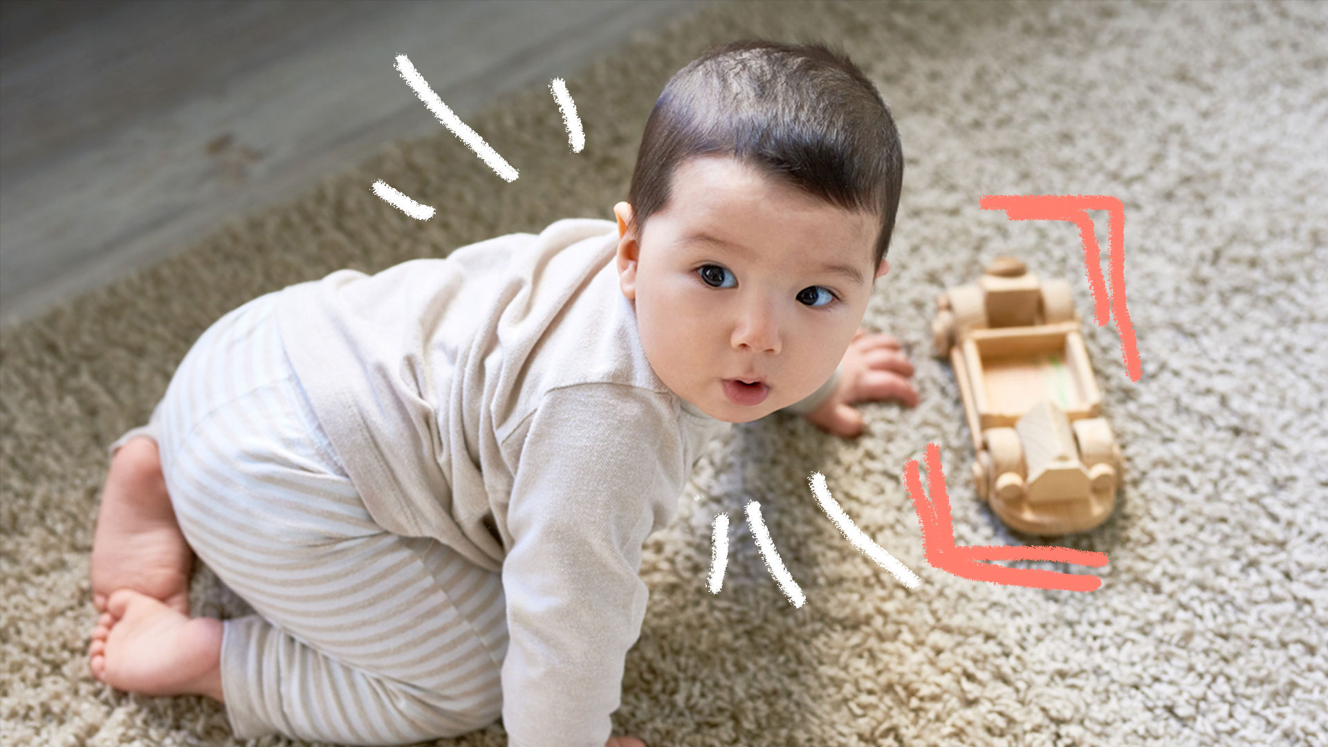 Bebê engatinhando em tapete felpudo, onde há um carrinho de brinquedo feito de madeira.