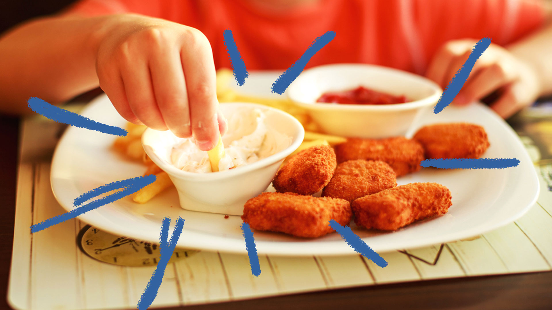 Mãos de criança comendo nuggets com batata frita e maionese
