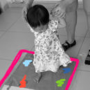 Bebê andando em cima de um painel sensorial de tinta.