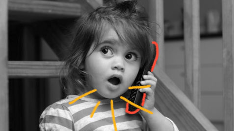 Atraso na fala: foto de uma menina que segura um telefone. Sua boca demonstra que ela está prestes a dizer alguma coisa.