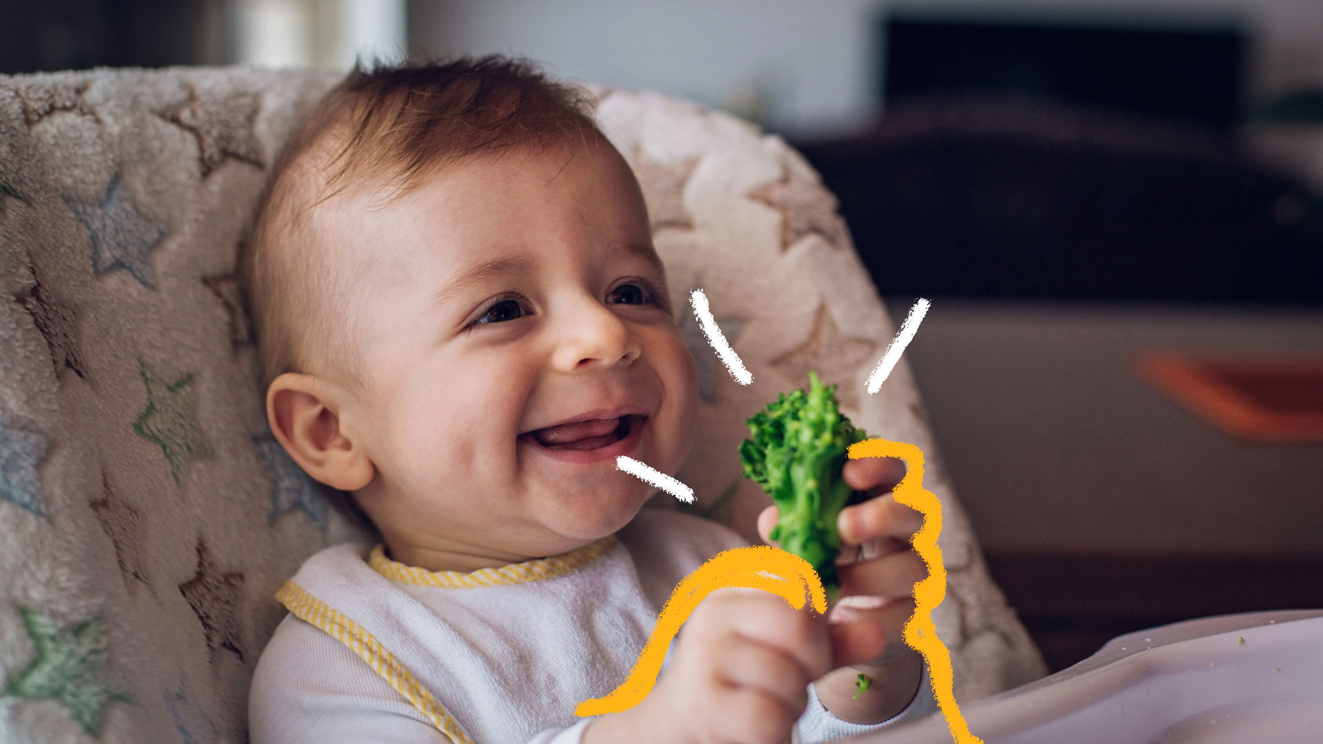 Bebê come sozinho um pedaço de brócolis e sorri.