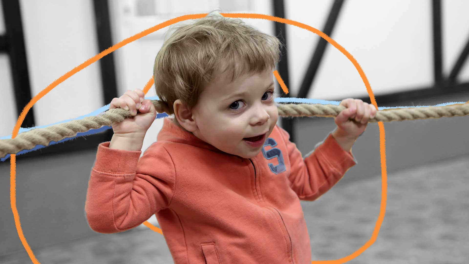 Um menino com um moletom laranja segura uma corda estendida atrás de sua cabeça
