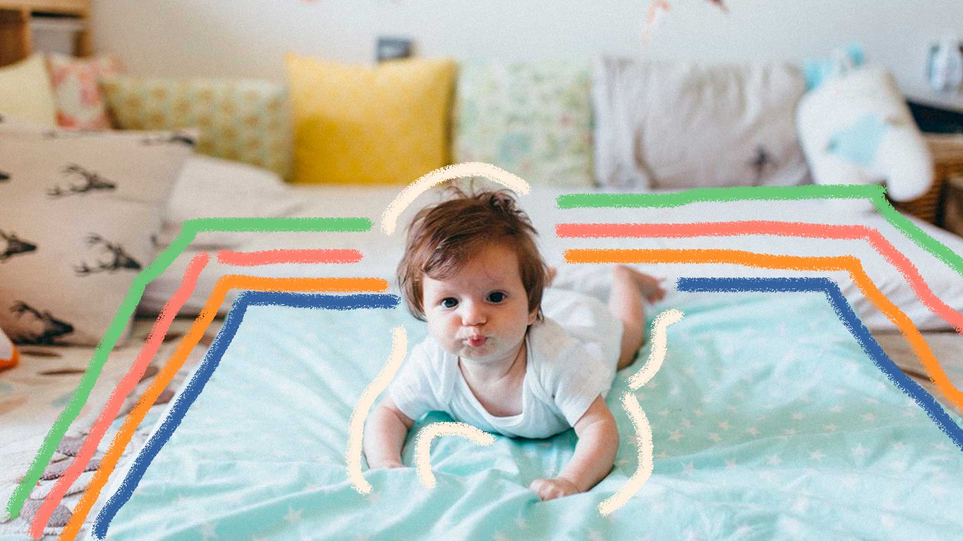 Quarto montessoriano: foto de um bebê que está de bruços e olha para frente. Ele está em cima de um colchão e ao fundo há almofadas.