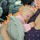 Uma mulher amamenta um bebê sentada em um avião