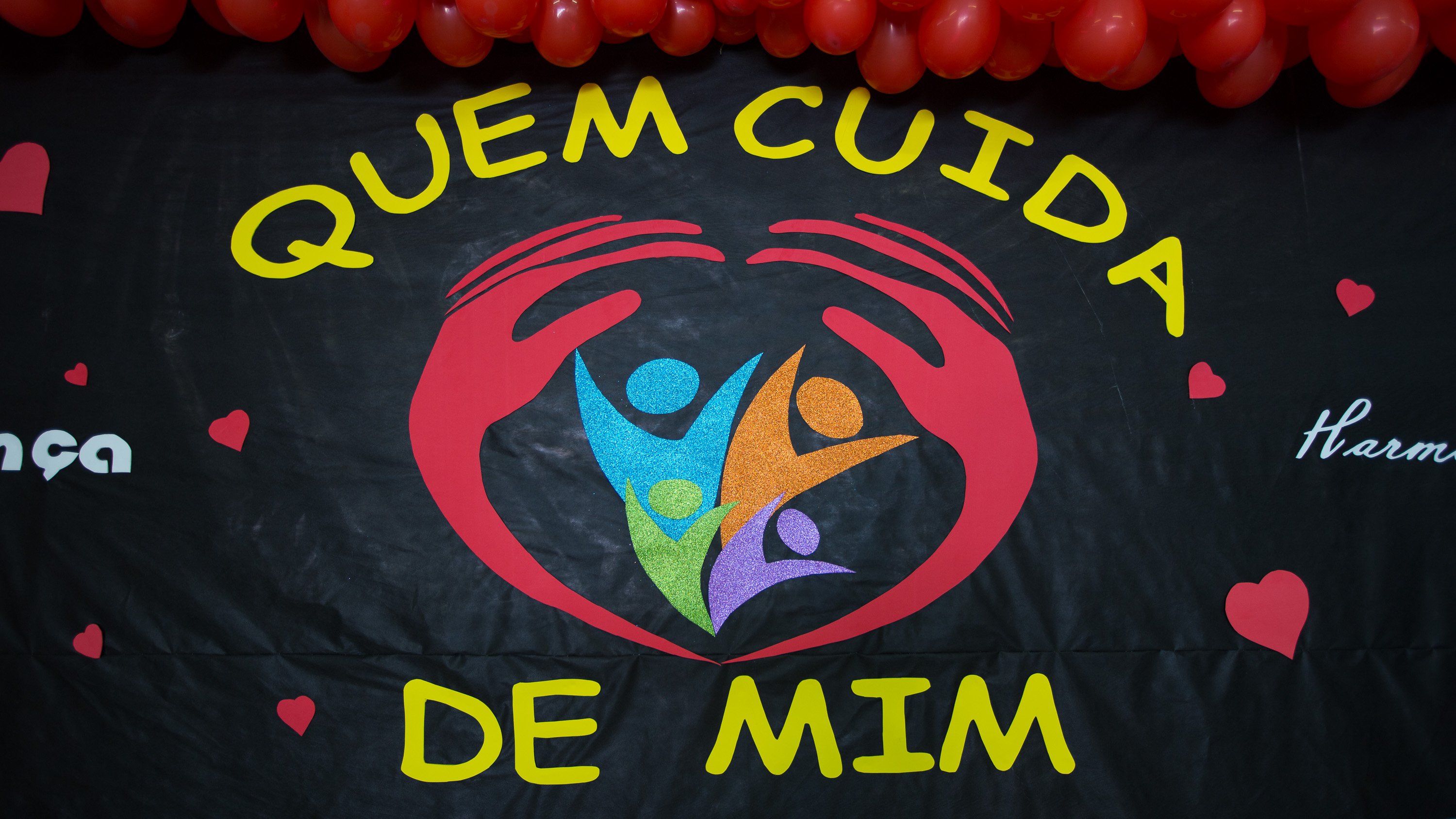 Um cartaz escolar colorido exibe os dizeres "Quem cuida de mim"