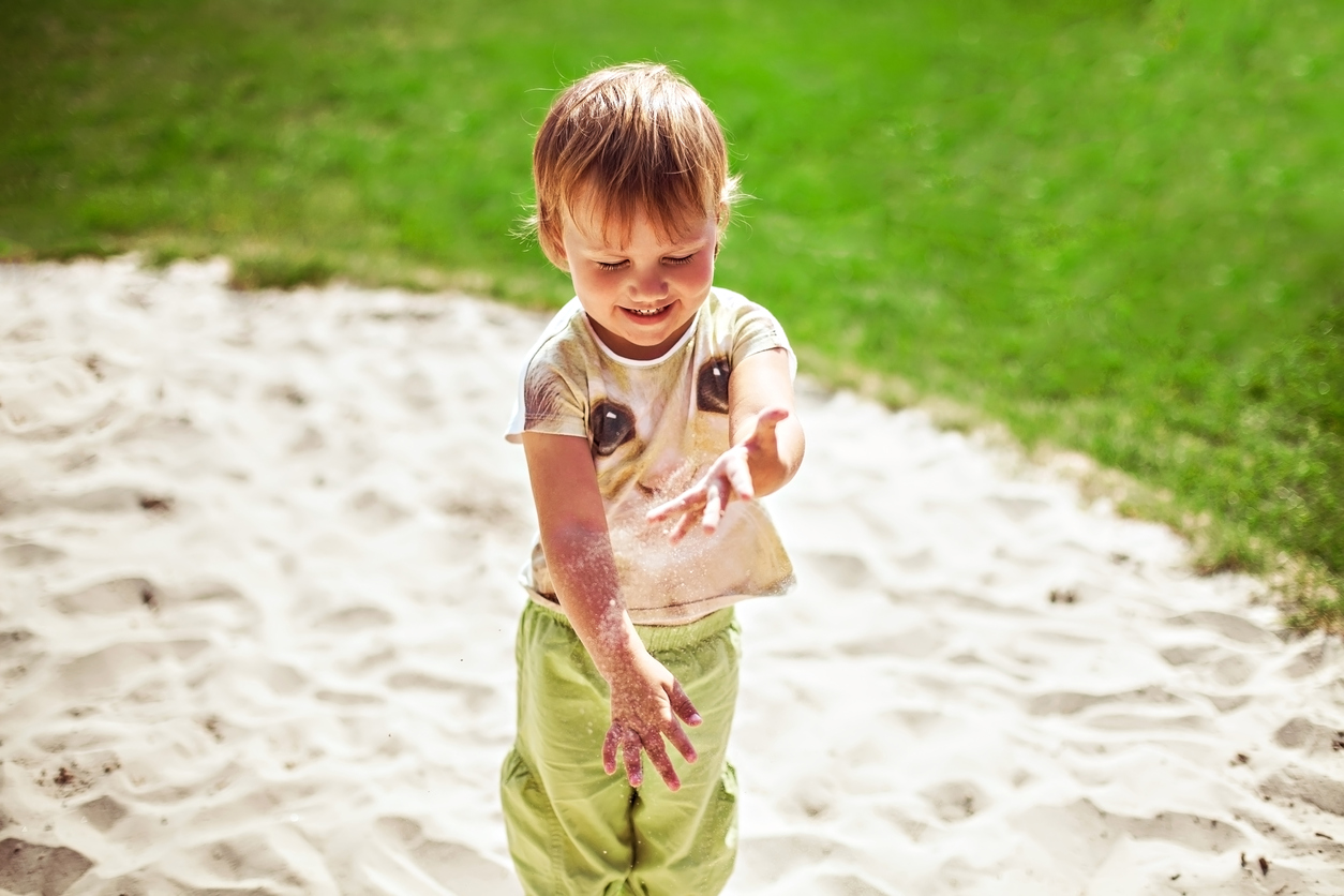 Criança brincando com areia.