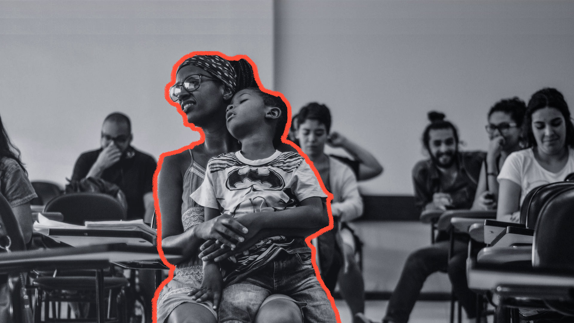 Mães na universidade: Imagem em preto e branco mostra uma mãe, em uma sala de aula, segurando seu filho no colo.
