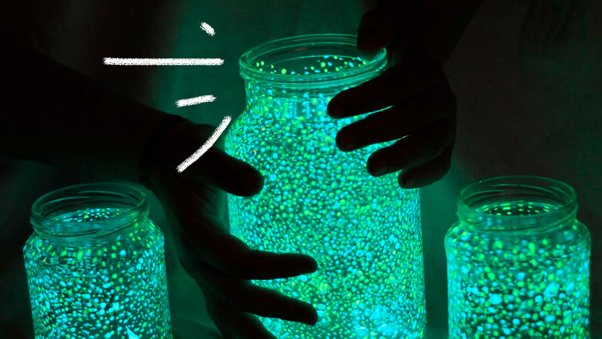 Dois potes de vidro transparente com água glitter verde brilhando no escuro.