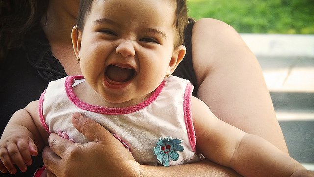 O Mundo Secreto dos Bebês: foto mostra bebê que olha para a frente e abre a boca.