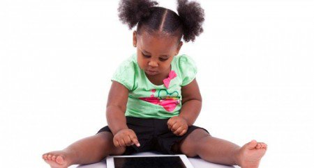 Aplicativos para autismo: foto de uma criança negra, que toca na tela de um tablet.