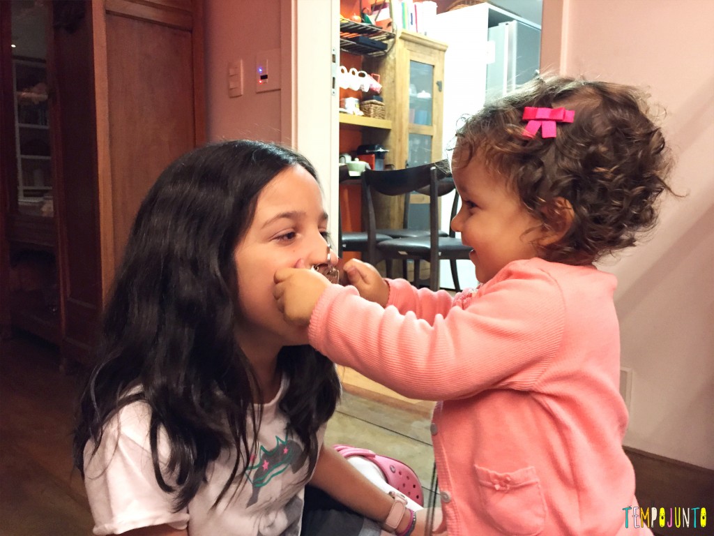 Brincadeiras para irmãos de idades diferentes: foto de duas crianças, uma mais velha e uma mais nova, que estão brincando.