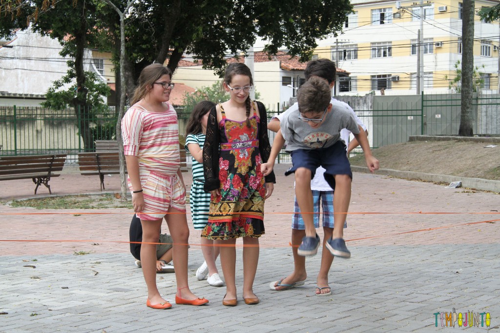 Brincadeiras de rua: grupo de crianças brinca de elástico na rua.