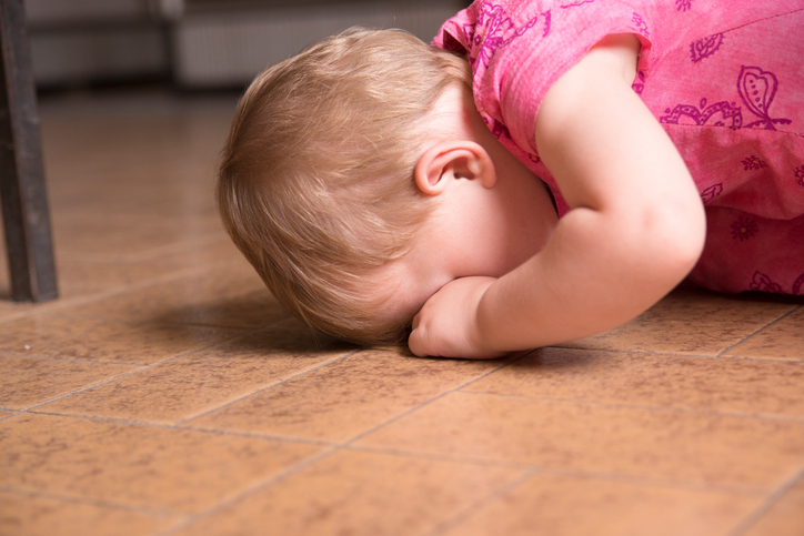 bebê fazendo manha e chorando com o rosto contra o chão