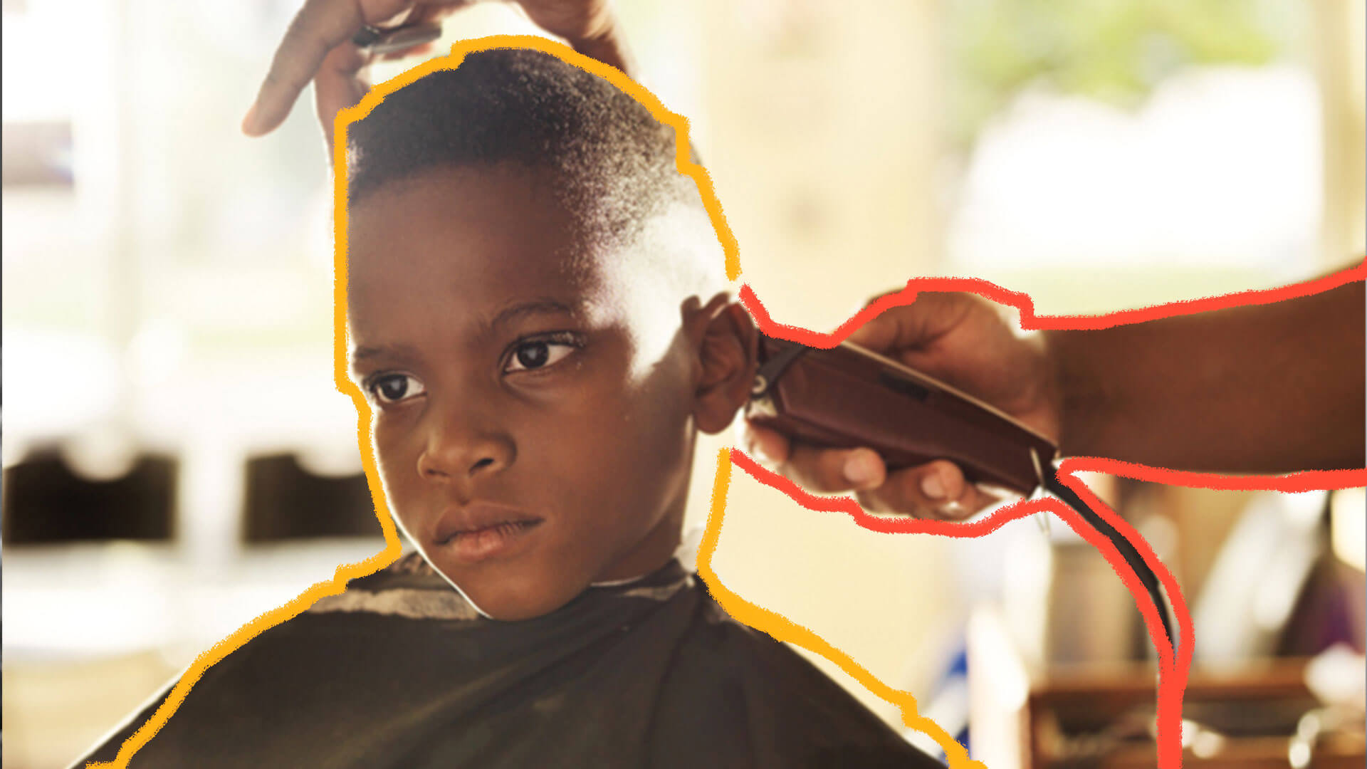 Rosto de menino negro com o cabelo curto sendo cortado por uma máquina, Aparece somente a mão de quem corta.