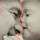 Foto em preto e branco. Bebê beija nariz de homem. Os dois estão de olhos fechados. Matéria sobre licença-paternidade.