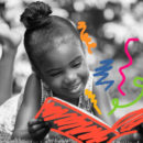 Literatura infantil: Menina negra lê um livro deitada na grama. A capa do livro é vermelha e dele saem grafismos coloridos.