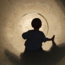 Menino brinca dentro de um túnel escuro