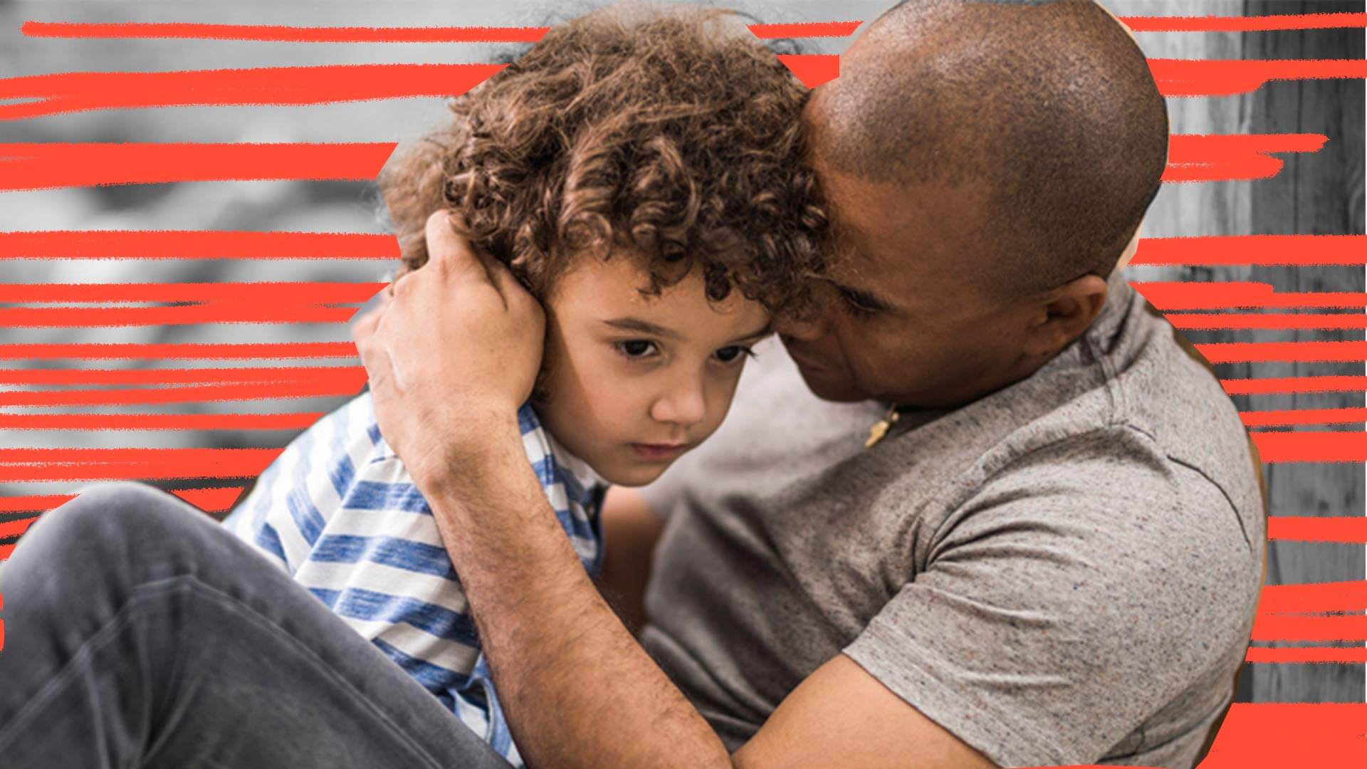 Homem negro segura menino de cabelos cacheados no pescoço e fala ao ouvido
