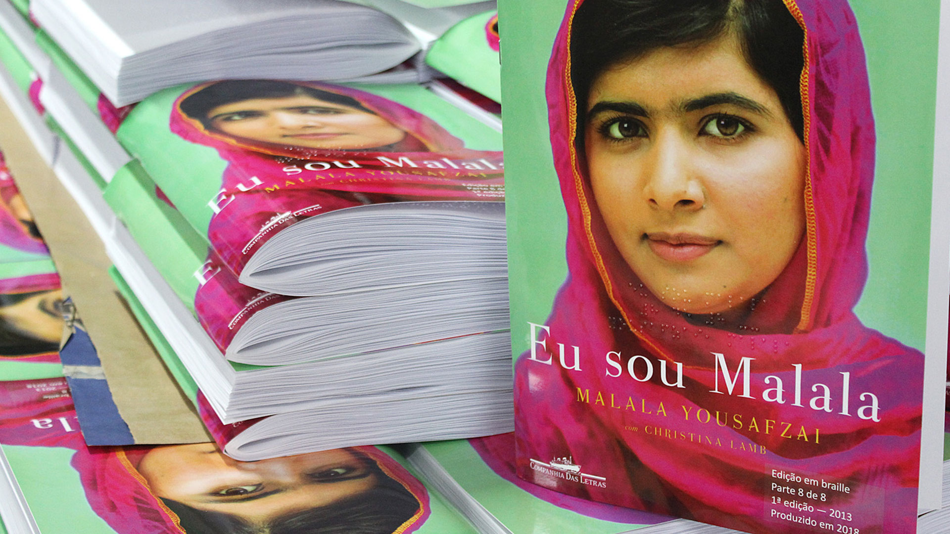 Capa do livro Eu sou Malala mostra a jovem paquistanesa Malala Yousfzai de lenço cor-de-rosa sobre um fundo verde.