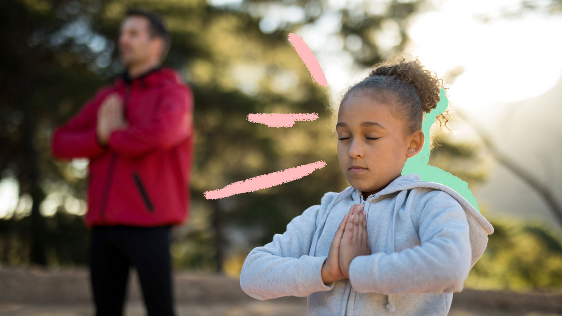Criança praticando meditação com a ajuda de um homem adulto, ao ar livre.