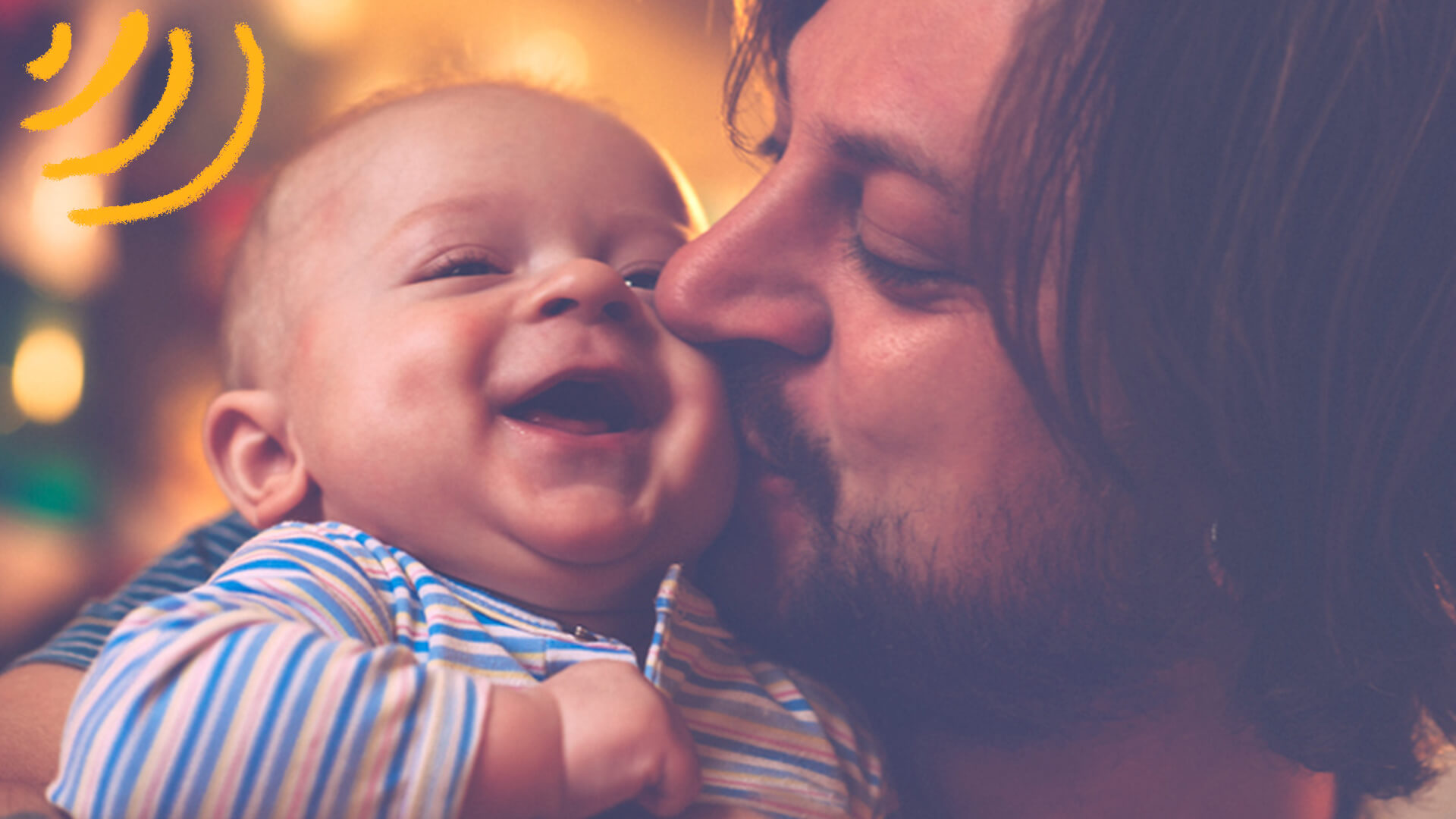 Homem beija a bochecha de um bebê que sorri