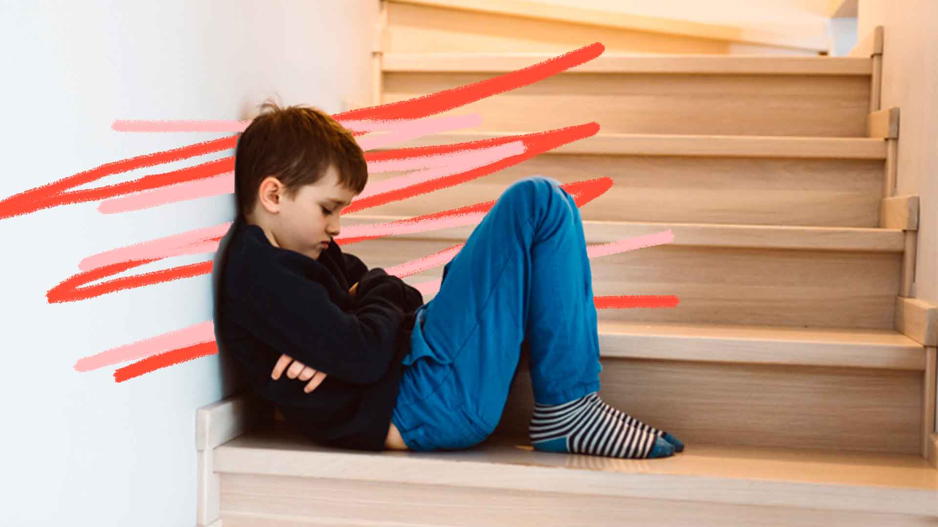 Punição? foto de um menino vestindo jeans e casaco preto, sentado no chão e encostado em uma parede, com braços cruzados e semblante chateado