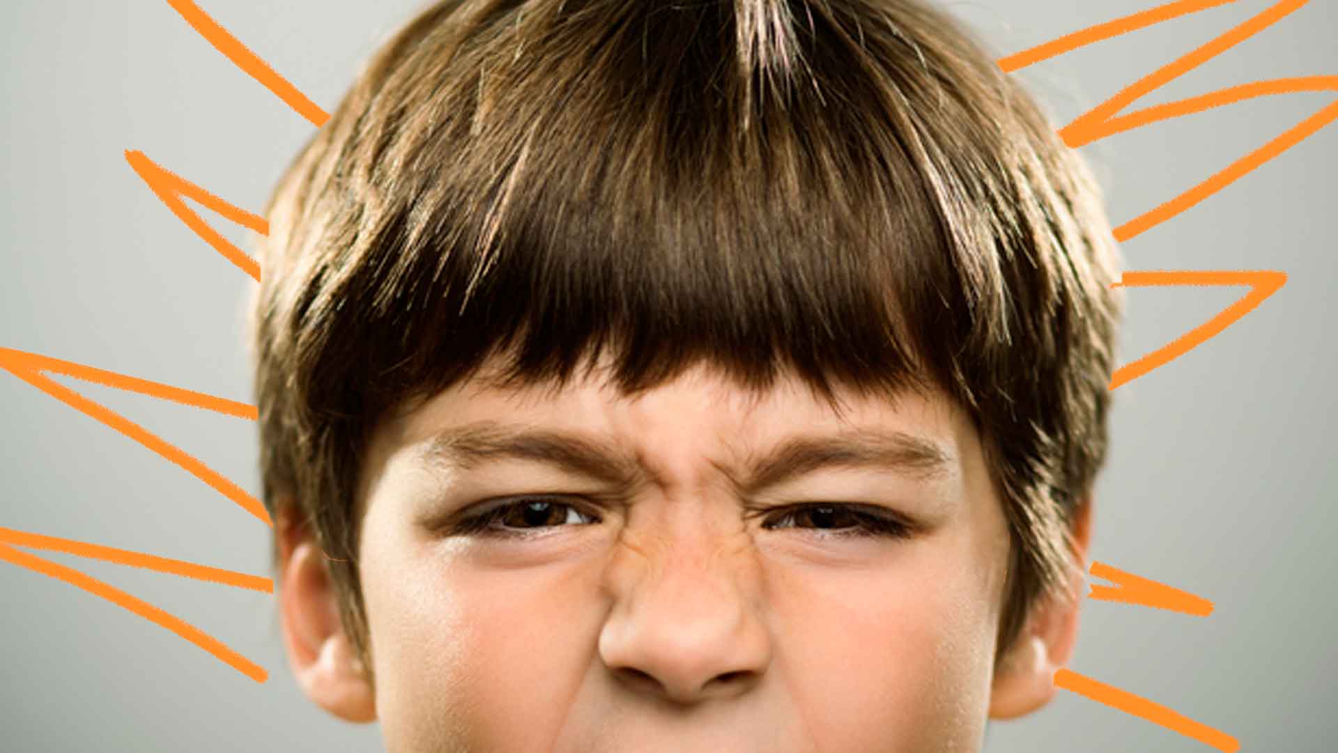 Foto de um menino com os olhos contraídos mostrando irritação