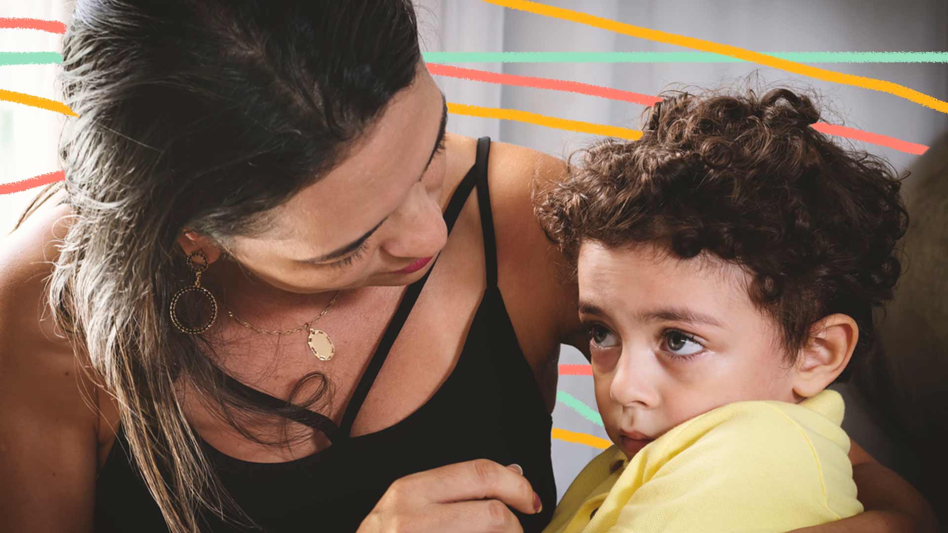 Foto de uma mãe abraçando seu filho, e olhando para ele, e o menino com olhar pensativo