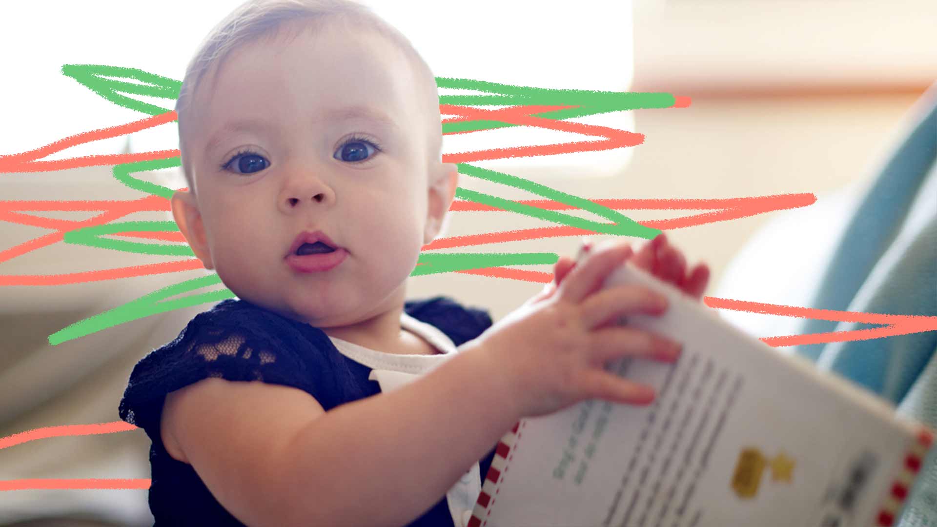 Foto de um bebê com as duas mãos segurando um livro, ele está olhando para o lado