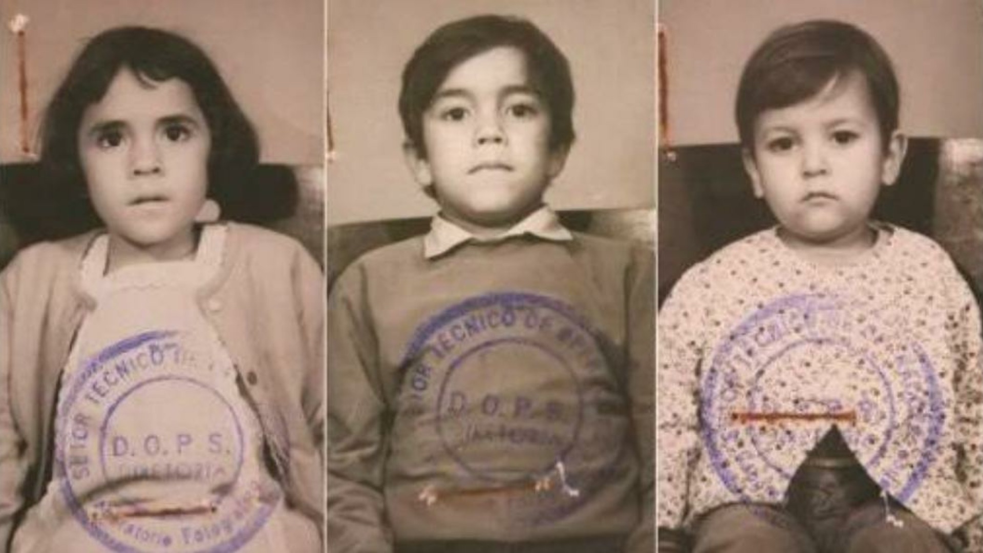 Foto de três crianças em preto em branco olhando seriamente com carimbos de ditadura em suas roupas