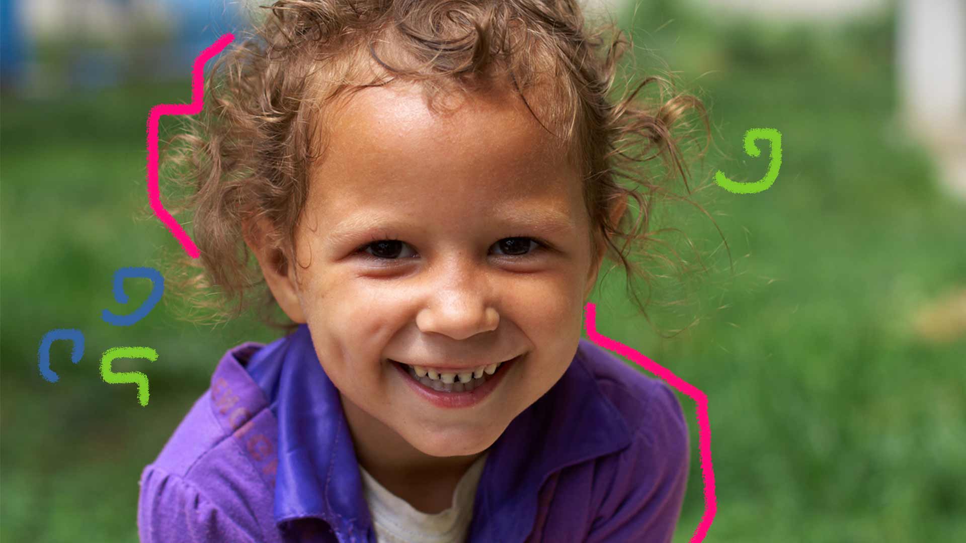 Foto de uma criança sorrindo em primeiro plano, atrás uma imagem fosca com o fundo verde