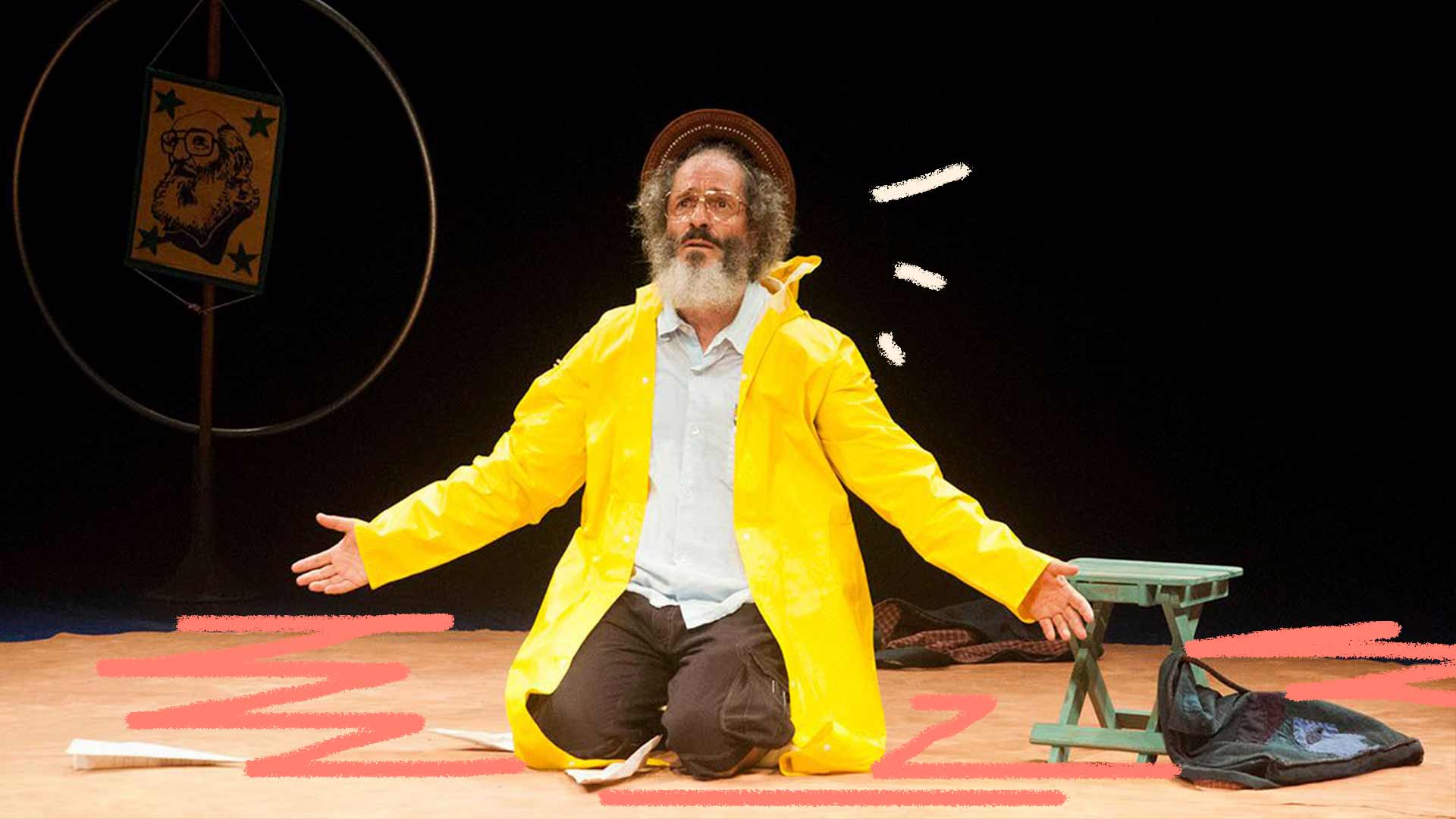 Foto de Richard Riguetti vivendo o personagem Paulo Freire em um palco de teatro. Ele está se apresentando ajoelhado com os braços aberto