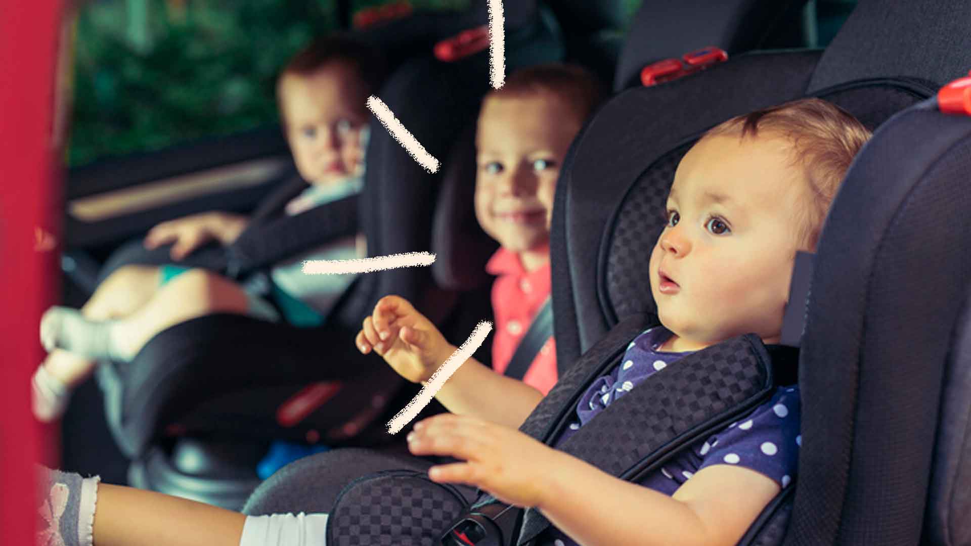 Foto de três crianças no banco de trás de um carro sentadas em uma cadeirinha. Os meninos olham pra menina sorrindo e a menina olha atentamente.