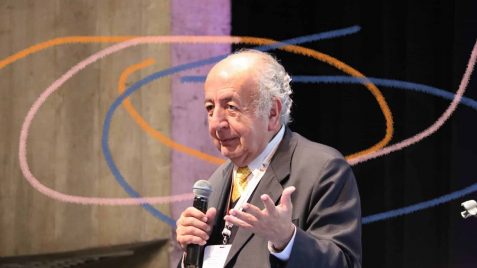 Imagem de Bernardo Toro um homem branco falando ao microfone com a mão estendida. Bernardo Toro é um dos mais importantes pensadores da educação e da democracia