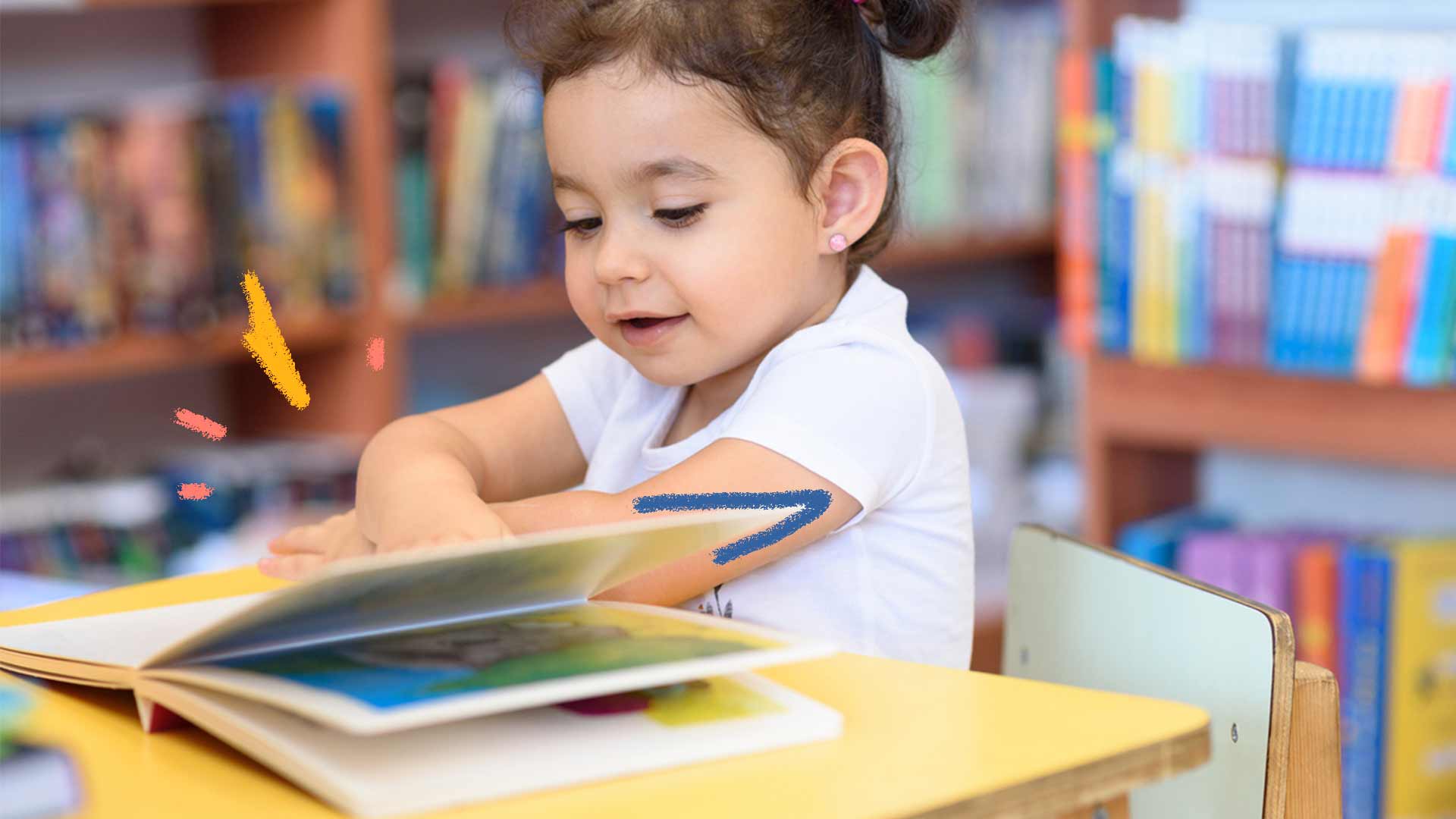Imagem de uma menina sentada em uma biblioteca com um livro infantil sobre a mesa