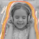 Imagem em preto e branco, de uma menina aparentando uns 5 anos de idade, com fones de ouvido, e sorrindo. A imagem tem a intervenção de rabiscos amarelos, laranja e branco.