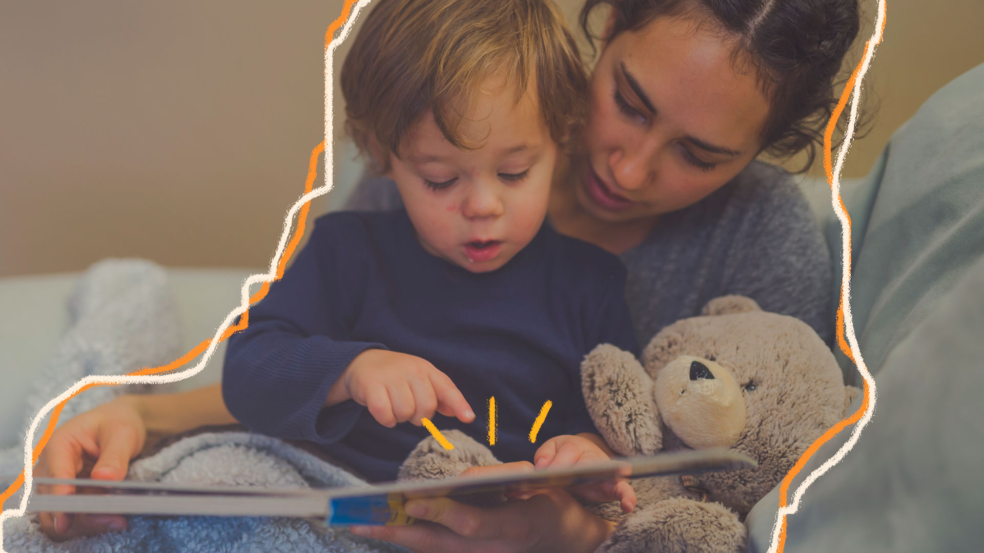 Imagem de um bebê de cabelos castanho-claro está no colo da sua mãe segurando um livro e um ursinho de pelúcia. Eles estão lendo o livro juntos