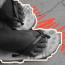 Imagem dos pés de uma criança negra usando uma sandália, expostos na rua. A imagem seria uma elucidação à exploração sexual infantil.