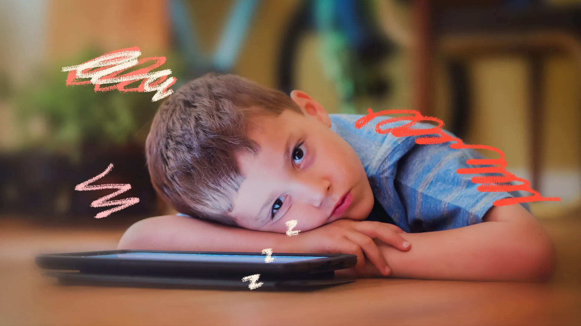 Telas e desenvolvimento infantil: um menino de cabelo castanho aparece debruçado sobre um tablet e aparenta estar um pouco cansado